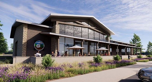 The New Moorpark City Library with glass windows, in front are sitting area with umbrellas and plants. Green trees in the background.