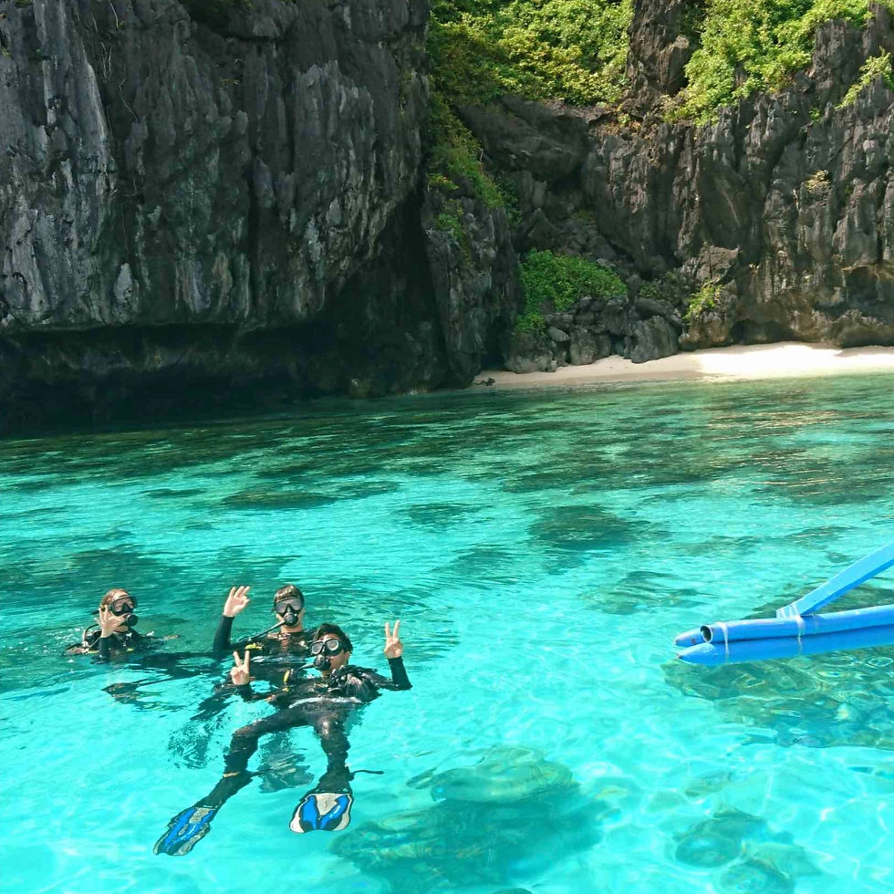 Group of beginner scuba divers practicing surface skills in shallow turquoise waters of Entalula Island.