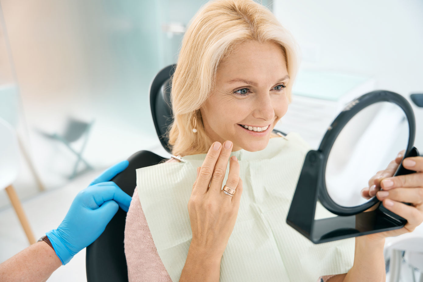woman with a beautiful healthy smile looking in the mirror