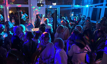 Foto von einer Party mit DJ Moni. Man sieht viele tanzende Menschen.