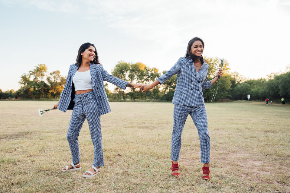 two women in plaid suits in field pose for fashion apparel photography in chicago