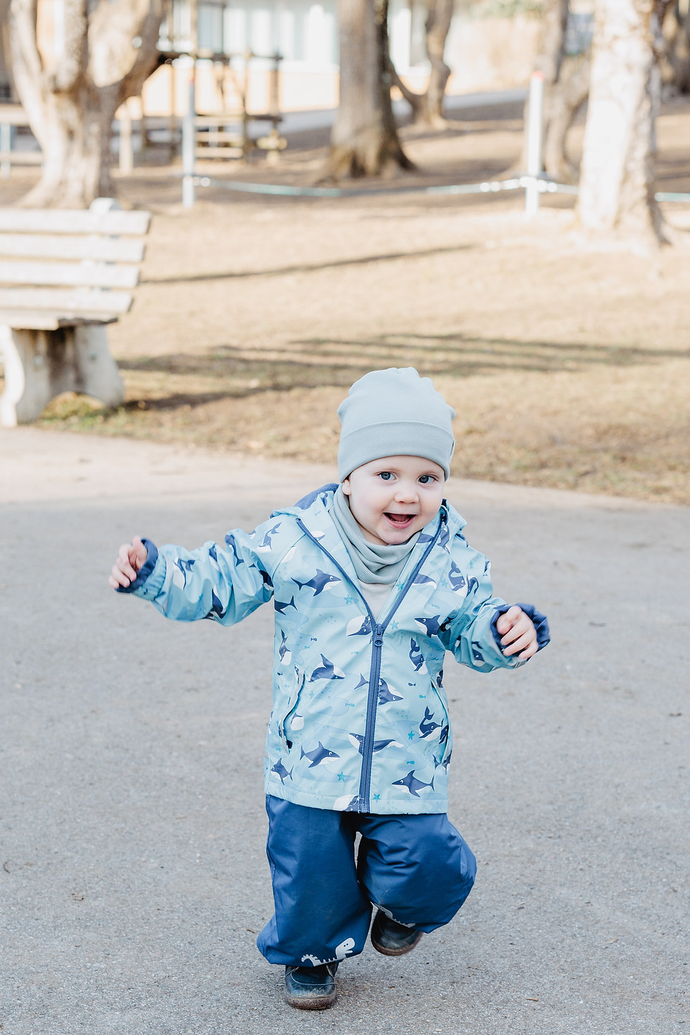 lachendes Kleinkind rennt über den Hof