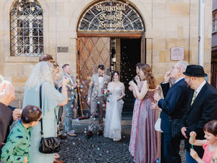 Glückliches Brautpaar dass nach der Trauung im alten Rathaus in Esslingen durch ein Gästespalier mit Seifenblasen läuft