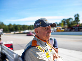 Ted Giovanis at the racetrack analyzing performance, representing racing data analysis and post-race evaluation.