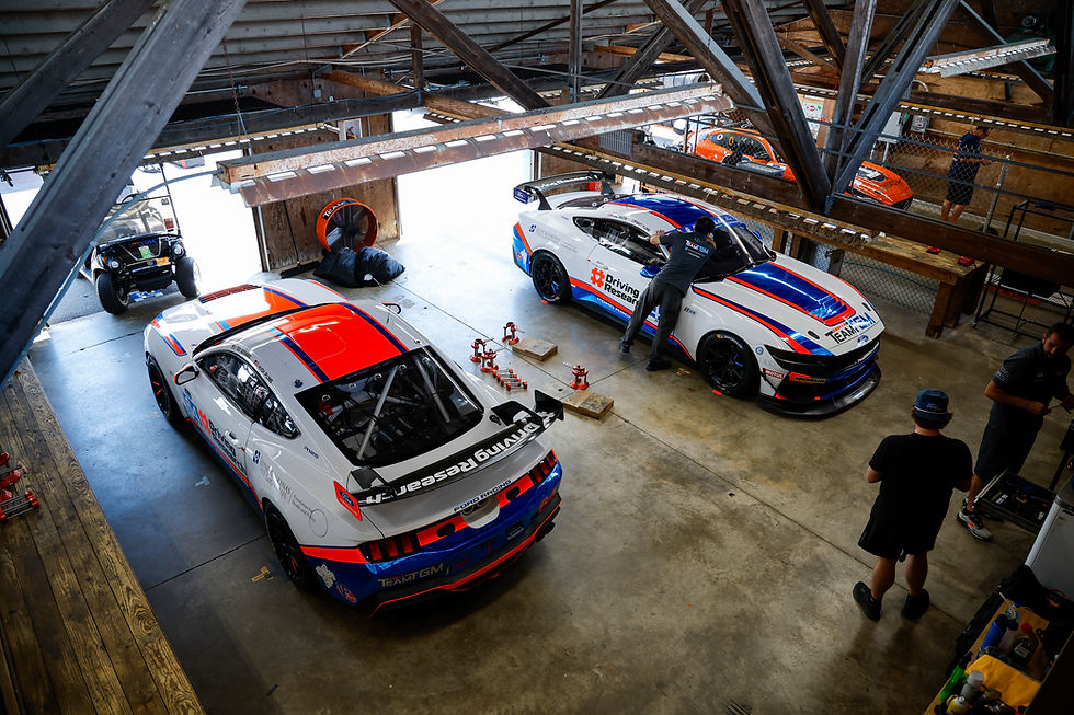 Team TGM crew working on Ford Mustang race cars in the paddock during the IMSA Michelin Pilot Challenge at Mid-Ohio.
