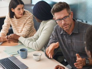 Team members engaged in constructive disagreement and discussion during a workplace meeting.
