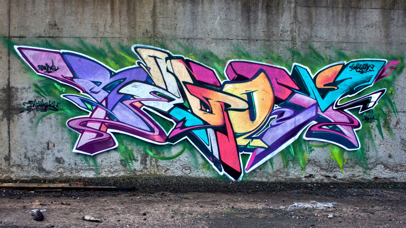 A multi-coloured piece of graffiti that is painted onto a wall