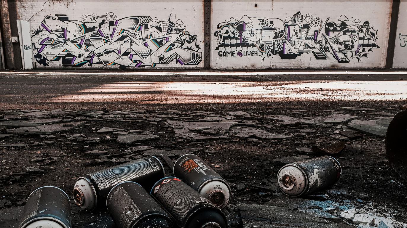 Amazing black and white graffiti art in an abandoned factory with cans of spray paint in the foreground by writer artist Rask and Mef Remo HBR Hated But Rated crew