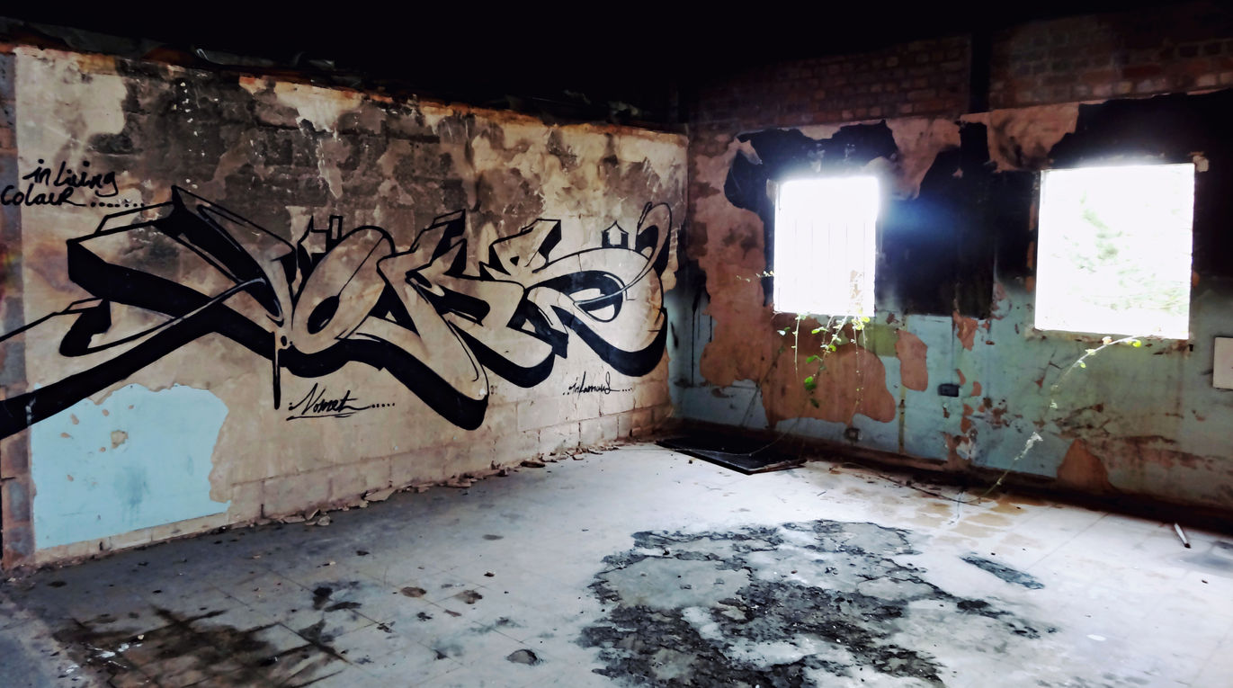 Hollow looking stylistic graffiti letters painted in a dark and shadow filled room bywriter artist Voms NFA crew