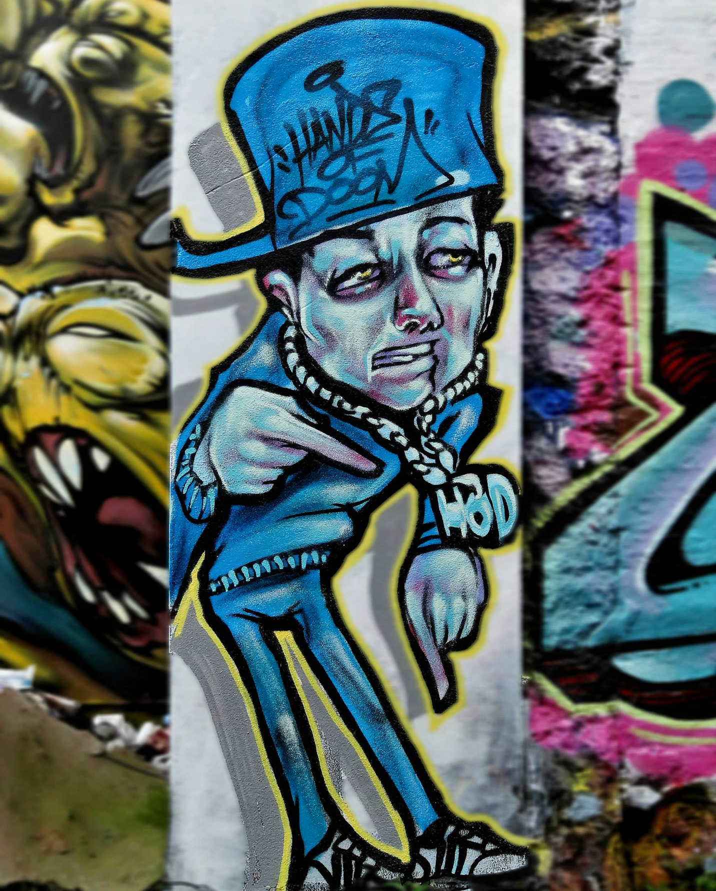A graffiti character wearing a cap backwards and wearing a gold chain