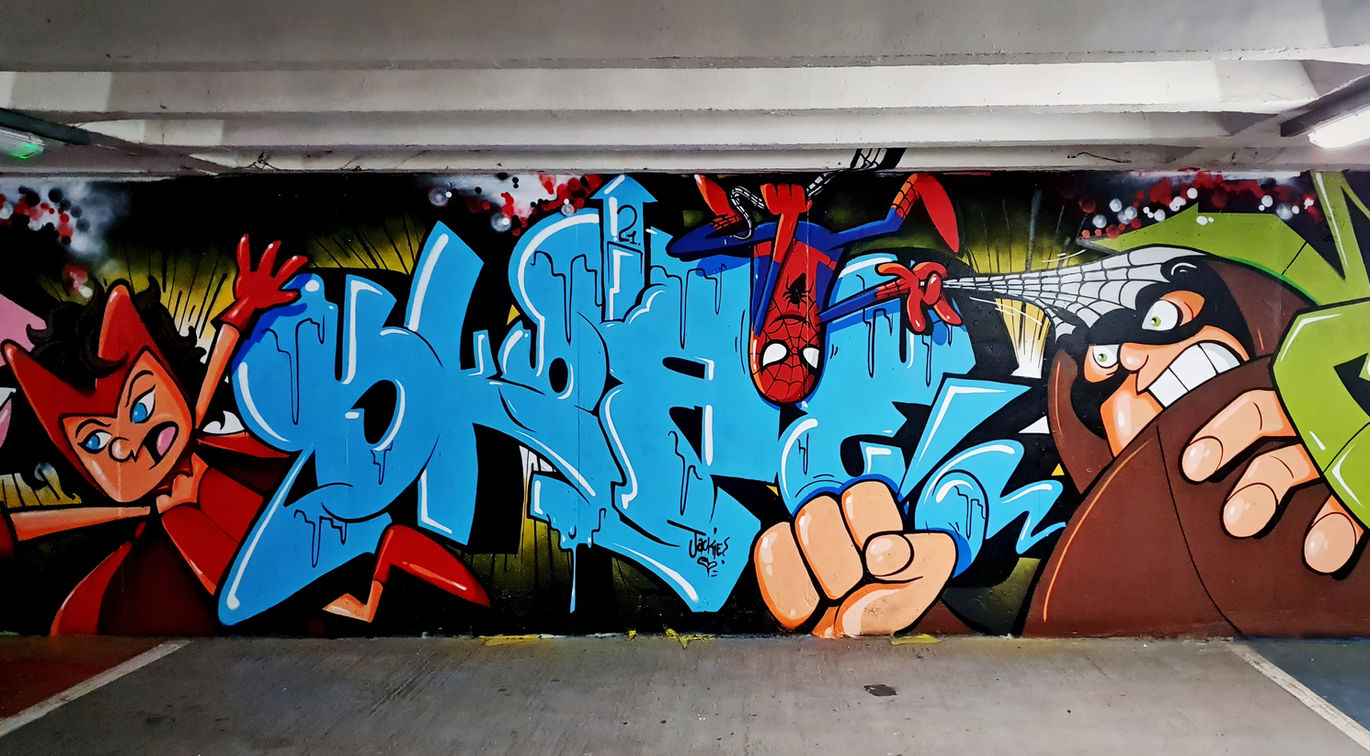 A finished graffiti wall by the artist Skore that features a character of comic book superhero Spiderman