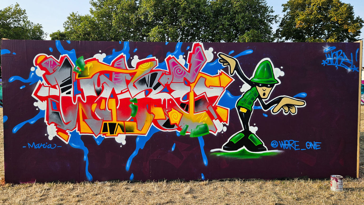 Brightly coloured graffiti letters featuring a bboy character striking a pose