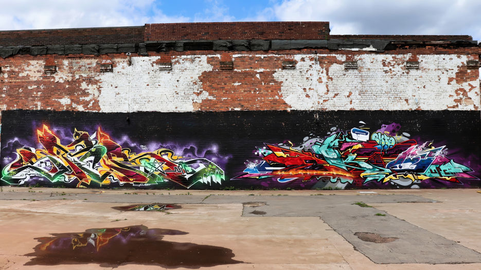 Brightly coloured graffiti lettering spray painted onto a wall