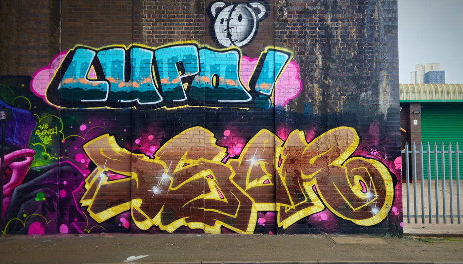 stylish graffiti letters painted on a dark brick wall in Birmingham