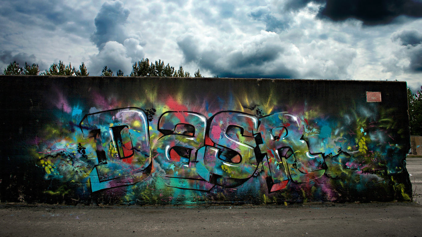Block graffiti letters, painted in an abandoned location, with an amazing cloudy sky