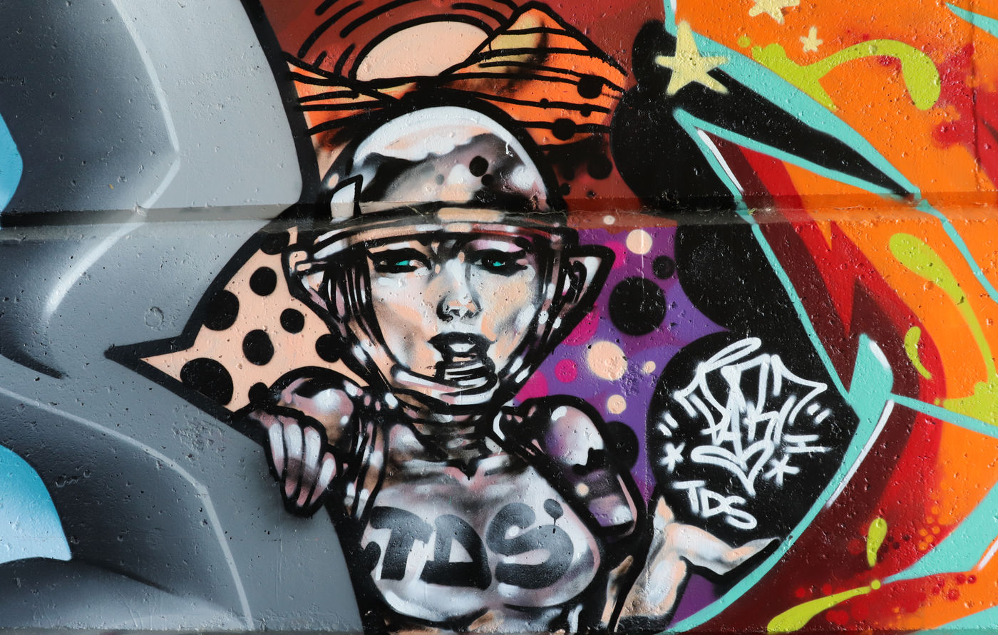 A space graffiti character holding a tag by Part One TDS