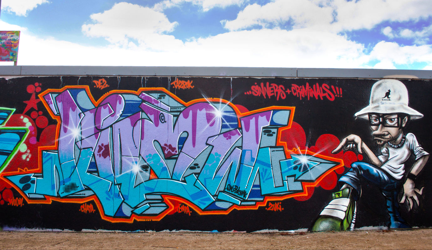 Purple and turquoise graffiti letters with a fresh looking character wearing a Kangol hat