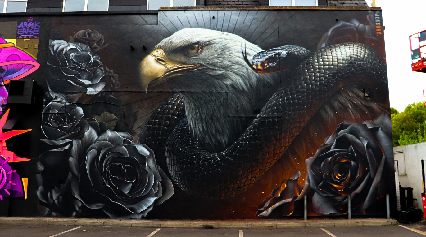 An amazing eagle, snake and flowers inspired piece of street art spray painted by the artist Jeks