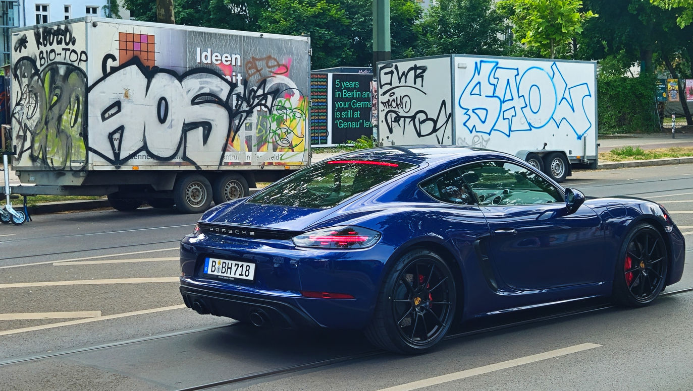 A sports car, in Berlin, driving passed some graffiti