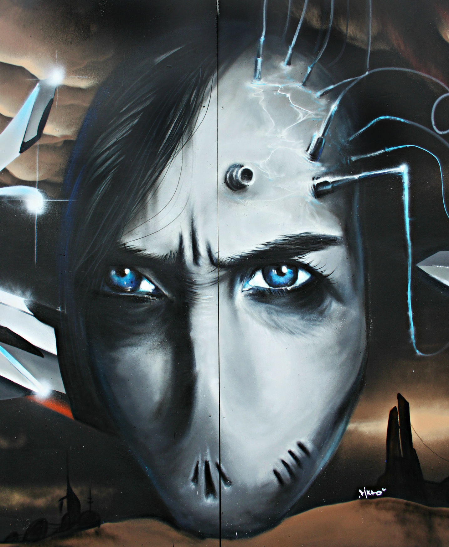 An insane piece of futuristic looking street art of the face of someone with no mouth and dark hair