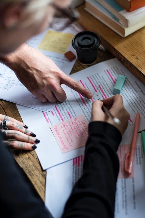 Two sets of hands reviewing a document