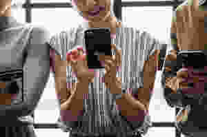 Three people looking at their cell phones
