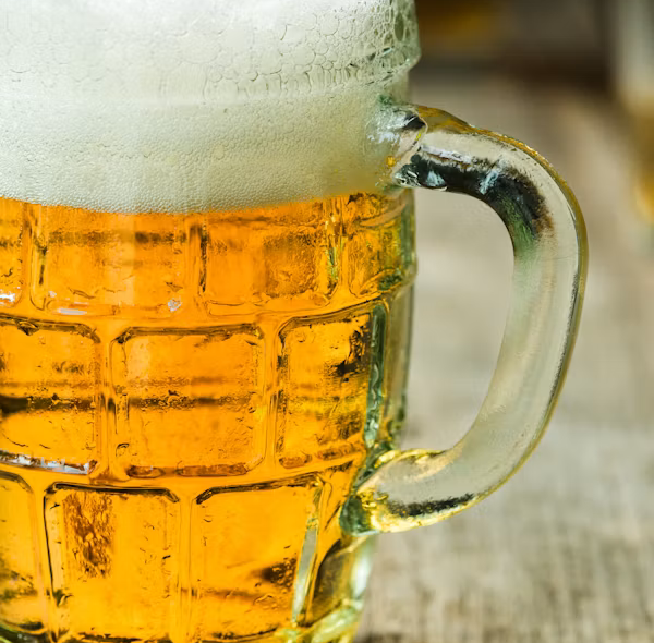 Frothy beer in a glass mug