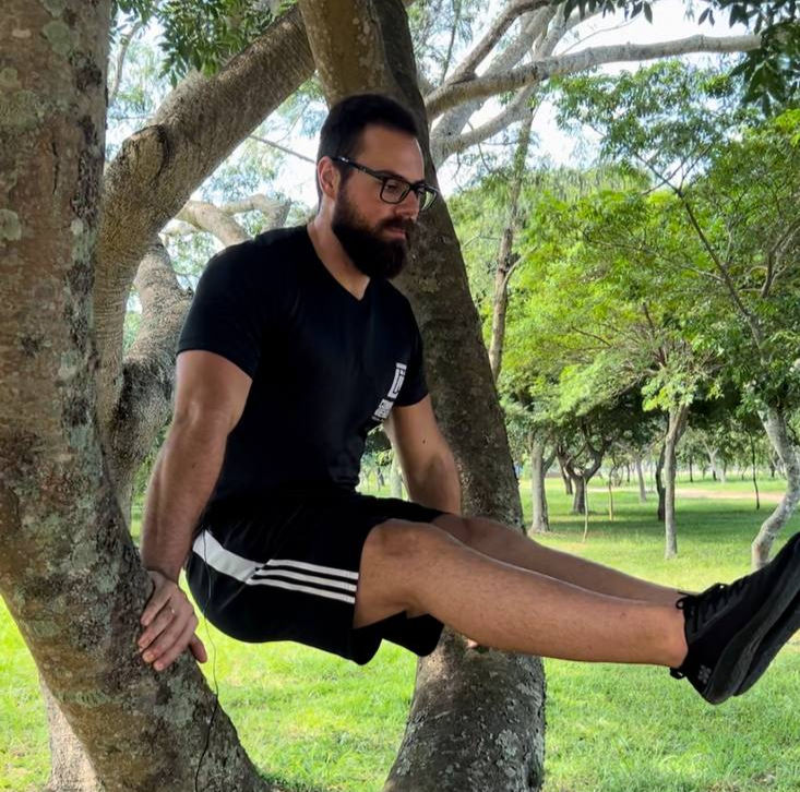 homem fazendo l-sit na árvore