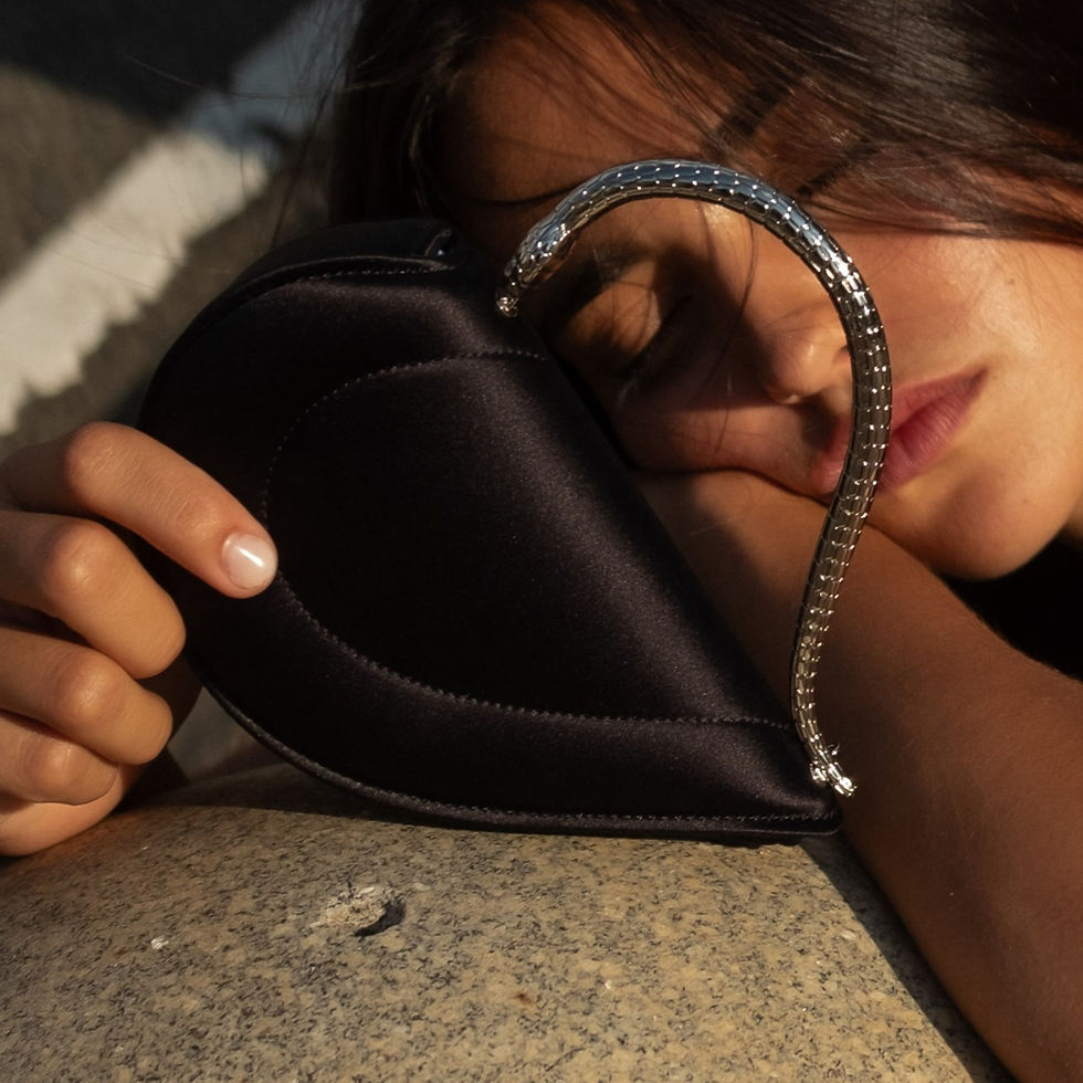 Close-up shot of Maia Reficco resting her head on a stone surface outdoors in Manhattan in the golden hour sunlight. She hold