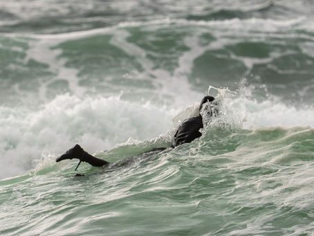 Surfer diving under a wave near Montara, California