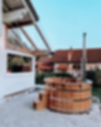 Badezuber aus sibirischer Lärche auf der Terrasse neben dem Haus