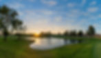 Sunrise over a golf course showing a water feature.