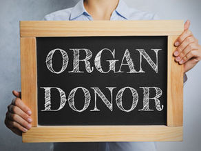 Image of a person holding a black board with the words "organ donor" written on it.