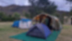 Image showing tents pitched with festive lights on and lovely mountains in the background.