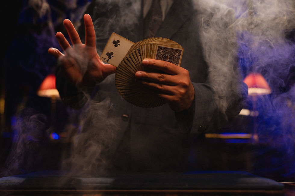 A magicians hands holding a deck of cards with the four of clubs showing.