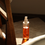 Thumbnail: Tall glass bottle of 'Daily Elements Oil Cleanser' with bright orange organic recipe