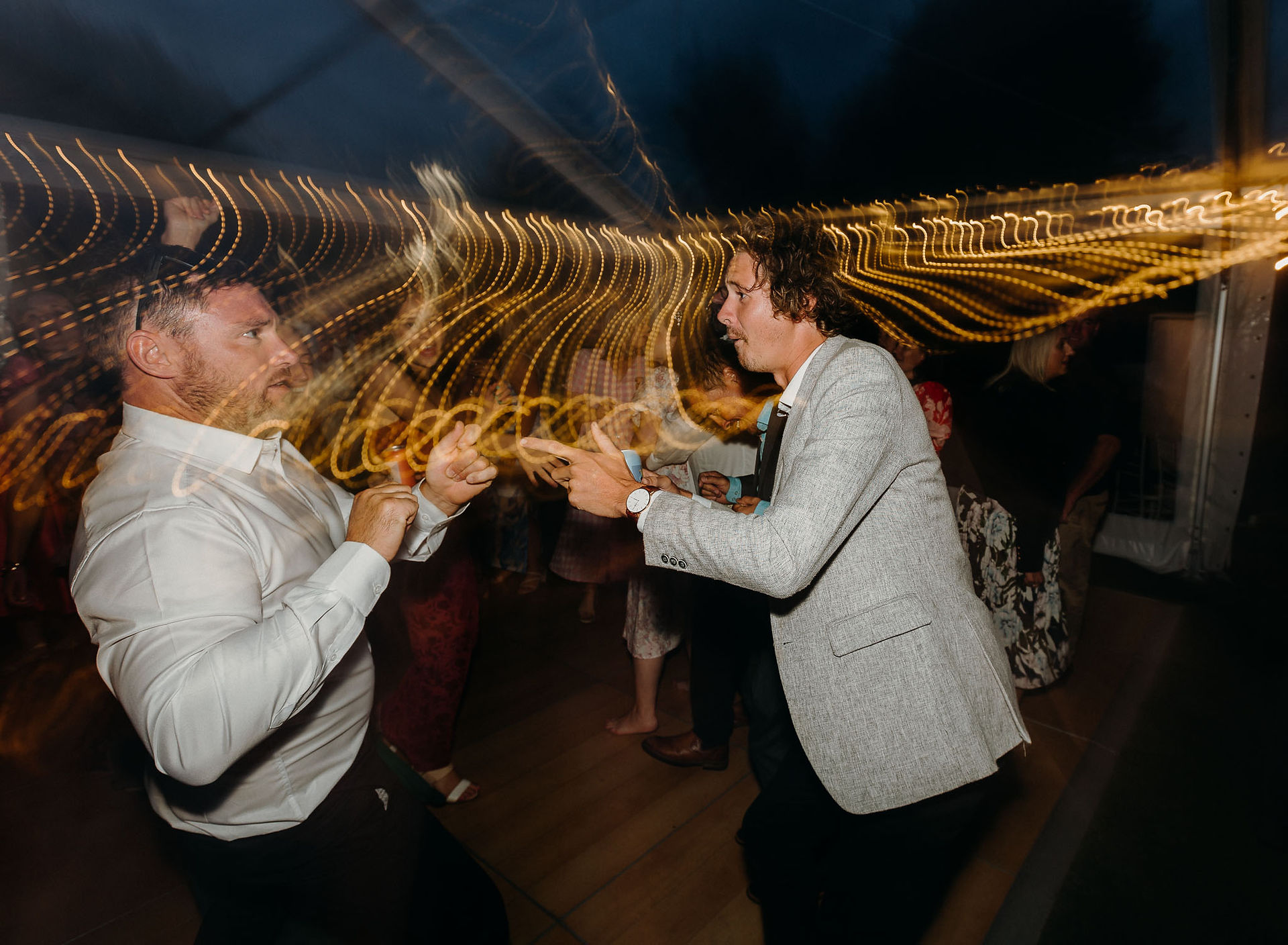 Wedding guests dancing beneath a clear marquee in Canterbury