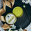 Thumbnail: yellow arnica relief balm in a gold tin on flowers