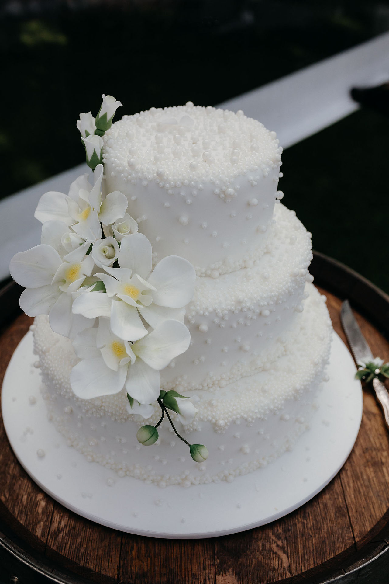 White wedding cake with pearl and floral details at a Canterbury wedding reception