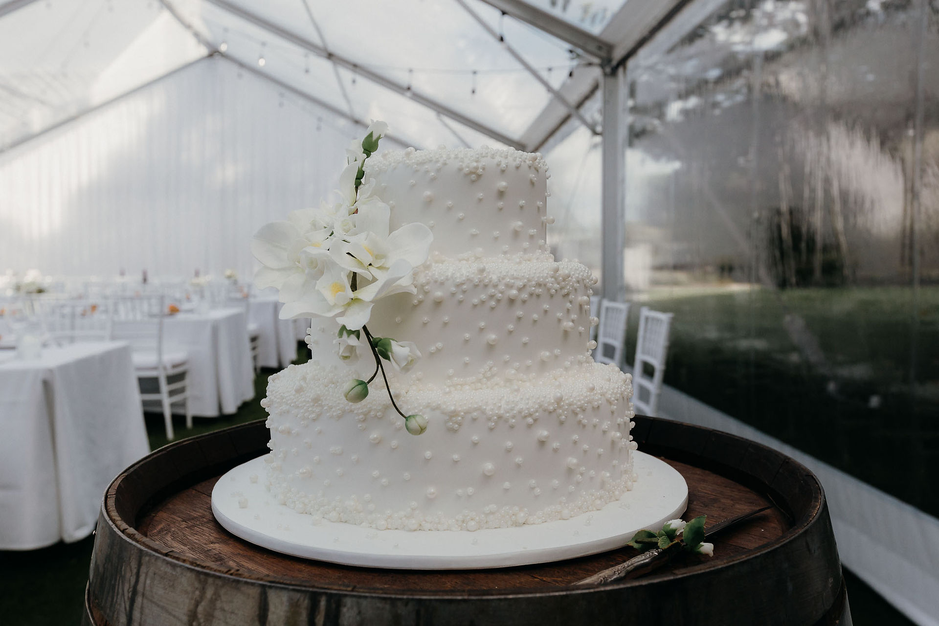 White wedding cake with pearl and floral details at a Canterbury wedding reception