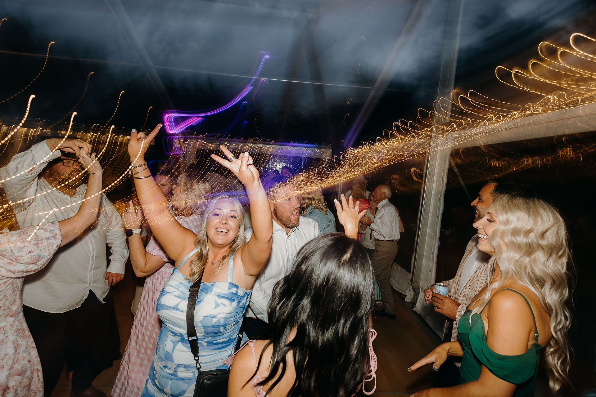 Wedding guests dancing beneath a clear marquee in Canterbury
