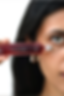 A long, thin glass tube of 'Shades of Red,' targeting and brightening dark under-eye circles.