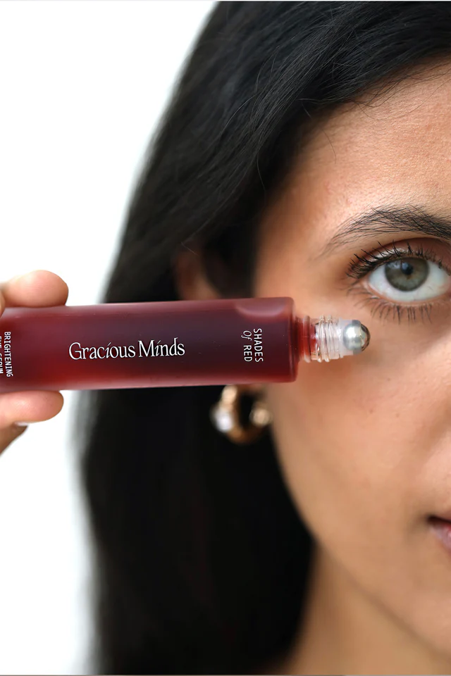 A long, thin glass tube of 'Shades of Red,' targeting and brightening dark under-eye circles.