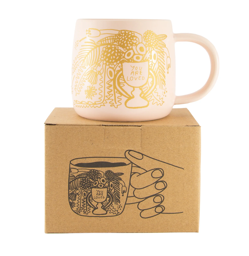 Blush pink ceramic mug with mustard floral artwork and “You Are Loved” message, with “Like A Lot” printed on the reverse.