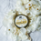 Thumbnail: yellow arnica relief balm in a gold tin on flowers