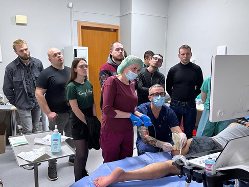 Ukrainian doctors observing pain management techniques during combat trauma treatment course at Main Medical Clinical Center