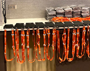 conference badges lined up ready to be printed for event. Orange lanyards hanging down.