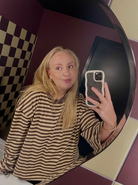 Amalie Hoelstad i en stribet langærmet t-shirt på et flow badeværelse tæt ved musemellow management