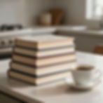 A stack of hardback books on a kitchen table beside a small cup of coffee