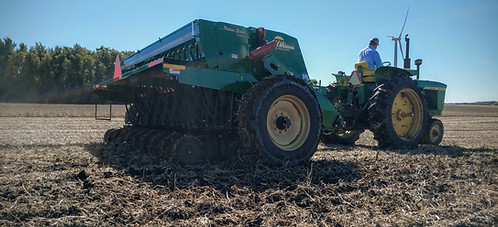 No till drill and tractor in field